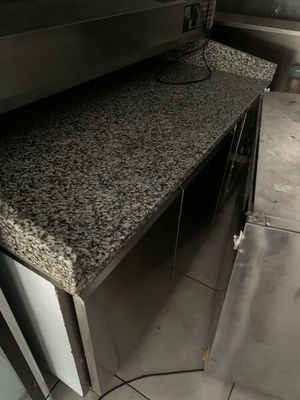 une photo d'une cuisine professionnelle équipée de plans de travail en granit et d'appareils électroménagers en acier inoxydable