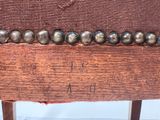 a close up of a wooden chair with metal balls on it
