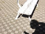 a white bench sitting on the side of the road
