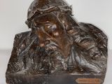 une statue en bronze représentant un homme barbu coiffé d'un chapeau