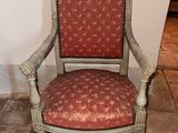 une chaise dont l'assise est recouverte d'un tissu rouge