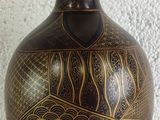 a vase that is sitting on a table with a white wall in the background