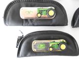 two black leather cases with green tractors on them on a white surface