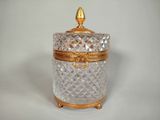 a glass jar with a gold lid sitting on a table