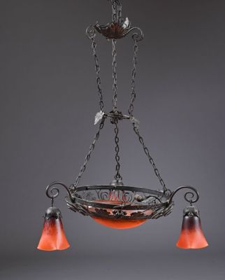 un lustre en fer forgé avec des abat-jours en verre orange