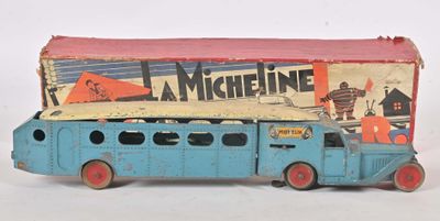 un petit bus bleu avec une boîte posée dessus