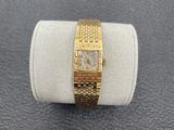 a close up of a gold wrist watch on a white ring
