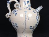 a blue and white vase with a handle on a black background