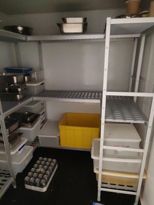 un garde-manger avec des étagères et des bacs remplis de provisions à l'intérieur