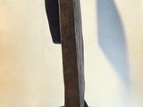 a wooden sculpture that is on a stand on a white surface
