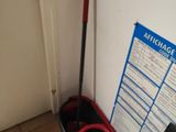 a mop and a bucket next to a sign on the wall