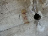 a piece of paper with writing on it and a hole in the wall