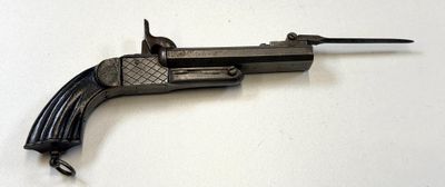 un pistolet posé sur une surface blanche