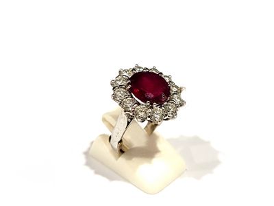 gros plan d'une bague en diamant et rubis sur une surface blanche