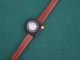 a close up of a wrist watch on a green surface