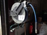 a hose that is attached to a reel in a garage