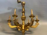 a gold colored chandelier with a bird on top of it