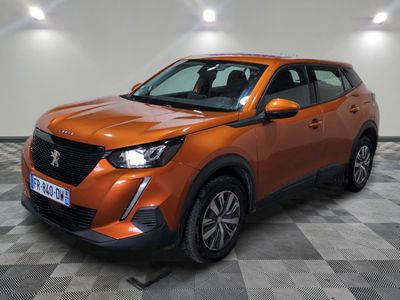 Le SUV orange est garé sur un sol en carrelage à damier.