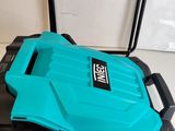 a blue lawn mower sitting on top of a table next to a wall