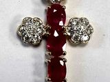 a close up of a red and white diamond cross on a white surface