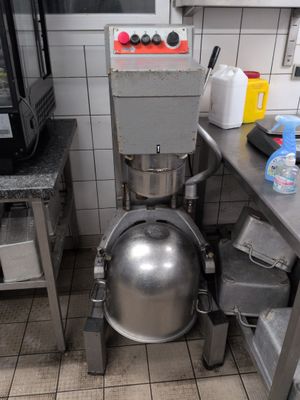 an image of a kitchen with a large metal ball on the floor