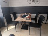 a table and chairs in a room with a bicycle on the wall