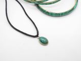 three bracelets with a green stone pendant on a black cord