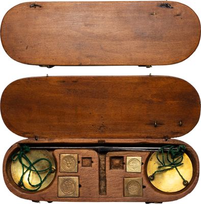 un coffret en bois contenant un objet en laiton