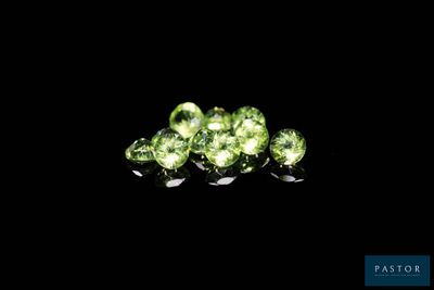 a close up of a group of green gems on a black background