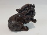 statue représentant un chien assis sur ses pattes arrière, la gueule ouverte