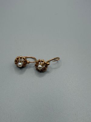 a close up of a pair of earrings with pearls on them