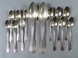 six silver spoons are arranged in a row on a table