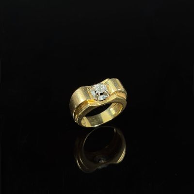 a gold ring with two diamonds on a black surface