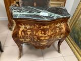 a marble top chest of drawers in the corner of a room