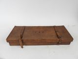 une vieille boîte en bois posée sur une table blanche