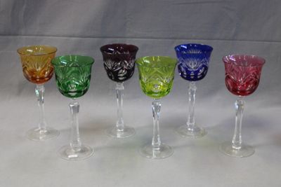several different colored wine glasses are lined up in a row