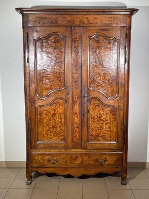 an image of a wooden armoire in a room with tile flooring