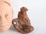 a clay head of a man next to a statue of a dog