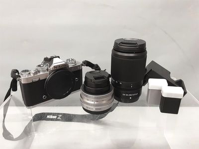 une photo représentant un appareil photo et un objectif posés sur une table