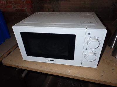 un micro-ondes blanc posé sur une table en bois