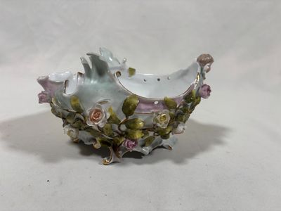 a small bowl with flowers on it on a white surface