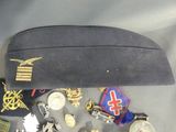 a black hat with a lot of pins and medals on it