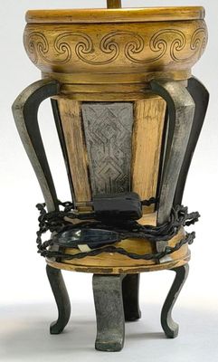 a wooden vase with a metal handle on a stand