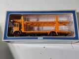 un camion miniature qui se trouve dans une boîte posée sur une table