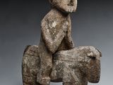 une image représentant une sculpture d'un homme assis sur un rocher