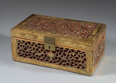 une boîte en bois richement décorée, munie d'une serrure, posée sur une surface blanche