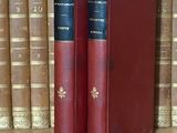 deux livres posés sur une étagère devant une rangée de livres