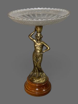 une image représentant une statue de femme tenant un bol posé sur une table