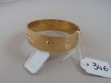 un bracelet en or posé sur une table blanche, avec une étiquette de prix