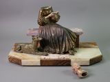a statue of a woman sitting on a bench reading a book